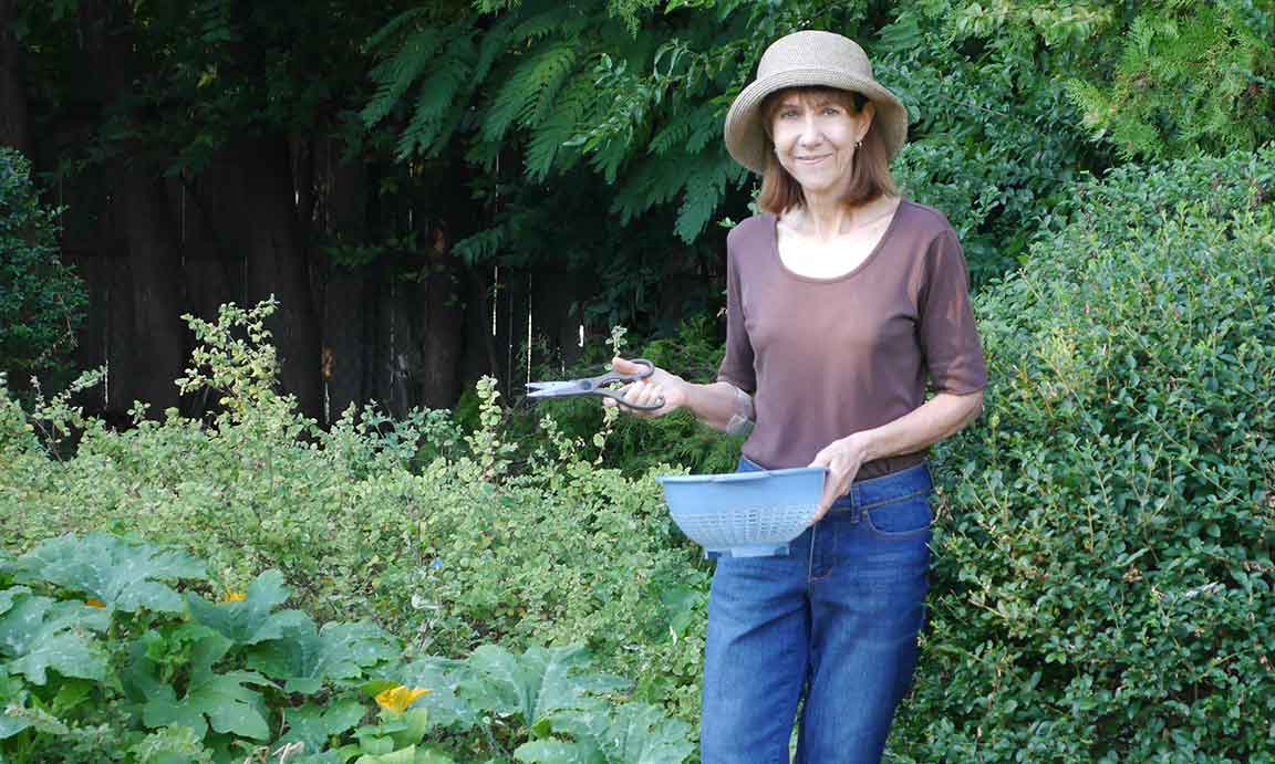 Anne harvesting squash blossoms