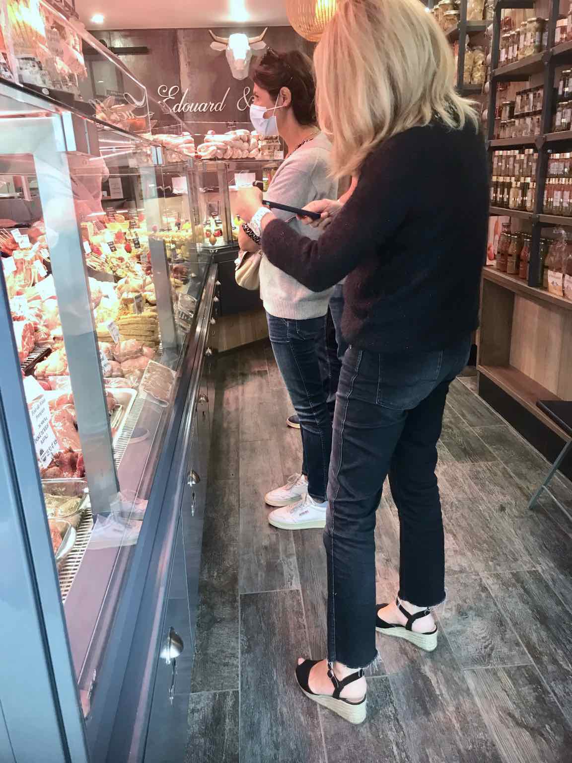 two women in front of shop meat counter