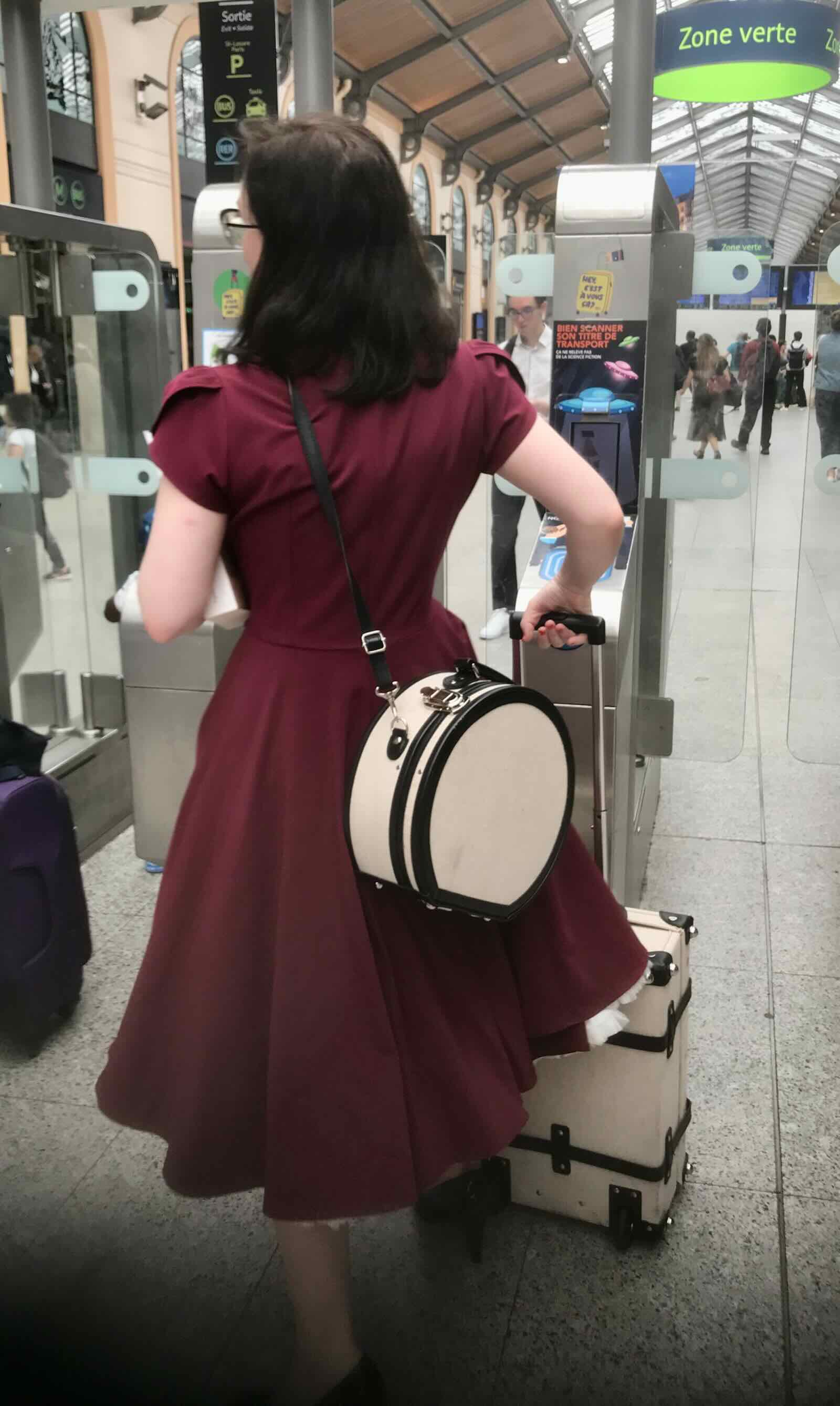 Girl in red dress with luggage boarding train