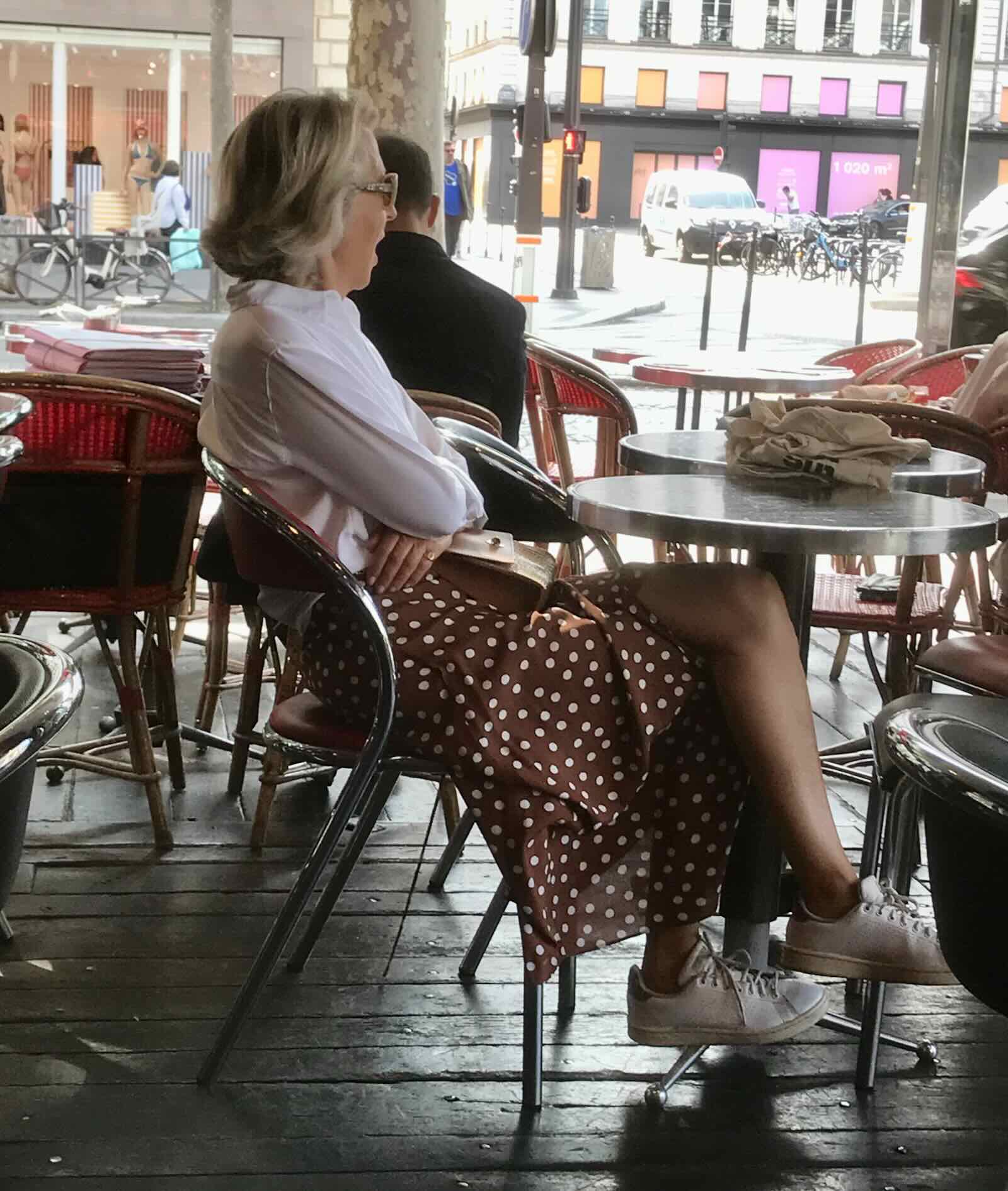 woman in white shirt and red datted skirt in cafe