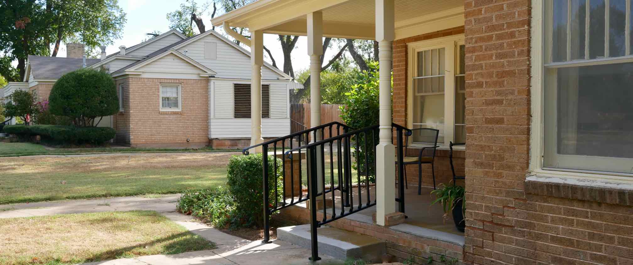 front  porch with black iron handrails for front steps